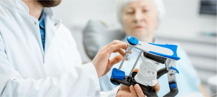 Dentist explaining a dental model to an elderly patient in Mentor